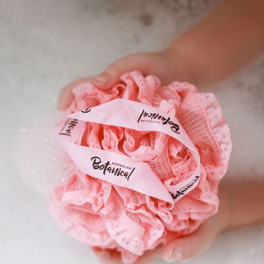 pink shower puff on top of bubbles