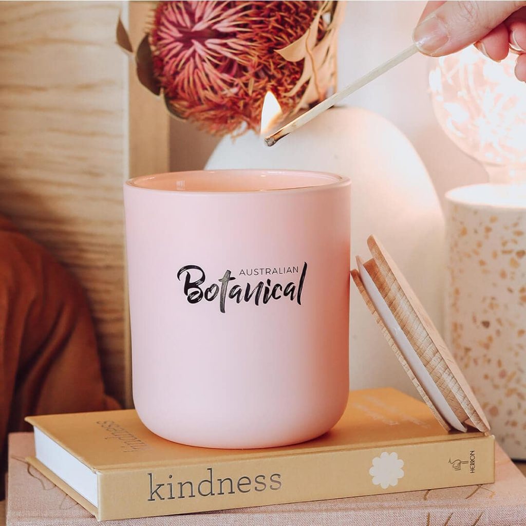 Pink soy candle being lit