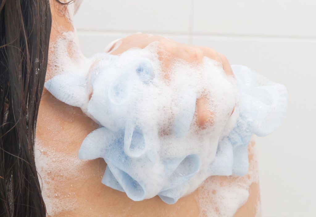 lady washing herself with shower puff