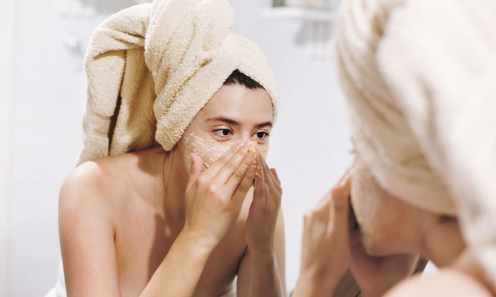 Women exfoliating her face after a shower